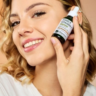 Mulher segura frasco de vitamina estável orgânica com conta-gotas