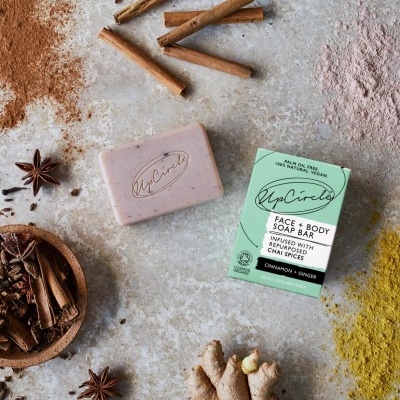 Sabonete UpCircle com embalagem verde e especiarias ao redor