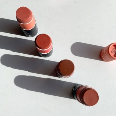 Batons em bastão em várias tonalidades de castanho e vermelho sobre superfície branca