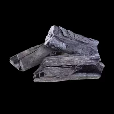 Carvão vegetal preto com textura rugosa empilhados em fundo preto