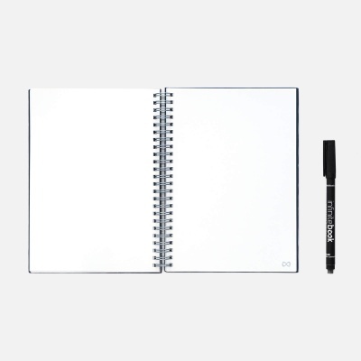 Caderno espiral aberto com folhas brancas e caneta preta ao lado