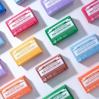 Barras de sabão coloridas embaladas com texto em inglês sobre superfície branca