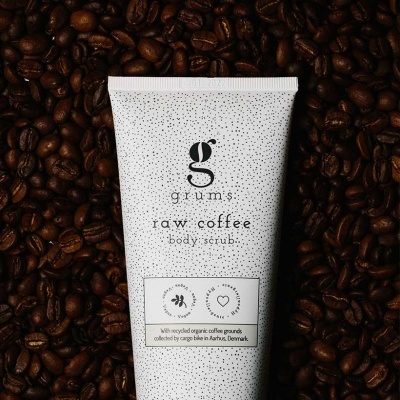 Frasco branco de esfoliante corporal raw coffee sobre grãos de café