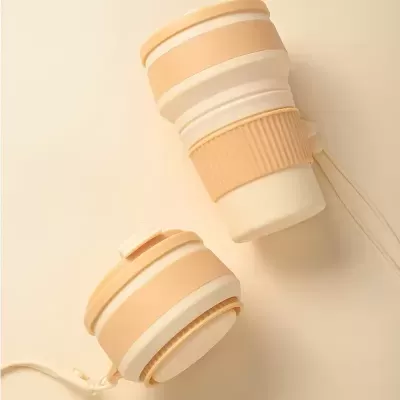 Colunas portáteis dobráveis beige e brancas sobre superfície clara