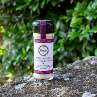 Frasco de shampoo seco Mirtitta em vidro com tampa preta sobre pedra ao ar livre