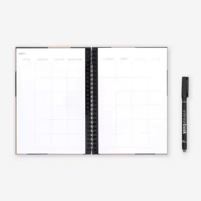 Agenda semanal com capa espiral e caneta preta ao lado