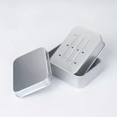 caixa metálica prateada com tampa e interior perfurado