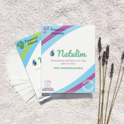 Caixas de detergente ecológico Natulim com tiras brancas e ramos de lavanda secos ao lado