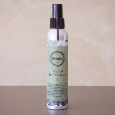 Frasco spray Tónico Refrescante Misttier com rótulo verde em superfície escura