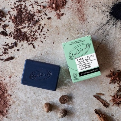 Barra de sabonete preta MoCielo com embalagem verde clara e especiarias ao redor