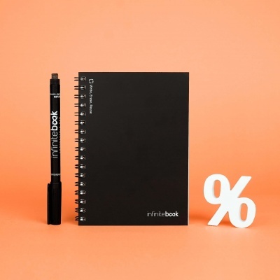 Caderno preto espiral com caneta preta e símbolo de percentagem branco sobre fundo laranja