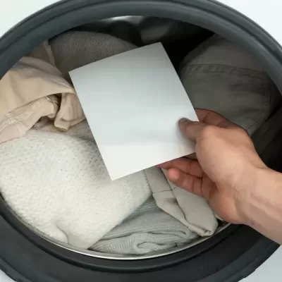 Vista superior de tambor de lavar roupa com mão segurando papel branco