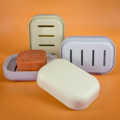 Caixas para sabão em plástico branco e cinza com bloco de sabão castanho