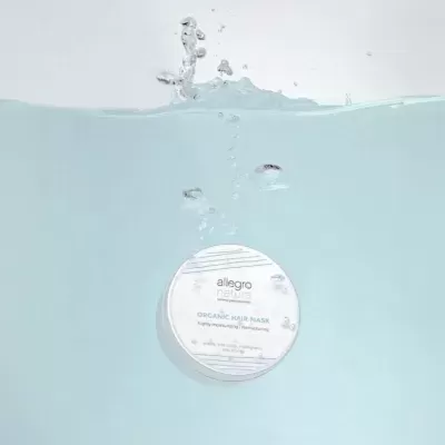 Frasco branco redondo Allegro Natural Organic Hair Mask submerso em água clara