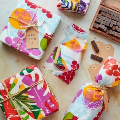 Presentes coloridos embrulhados com papel floral e etiquetas com texto 'with love x'