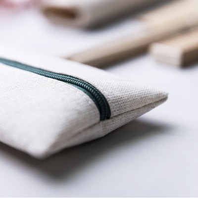 Estojo cinza claro com fecho verde escuro sobre superfície branca