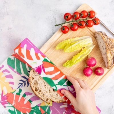 Tábuas de madeira com legumes frescos, pão de grãos e pano colorido com padrões de folhas