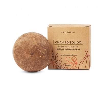 Champô sólido castanho e embalagem de papel castanho com texto e ilustrações laranja.