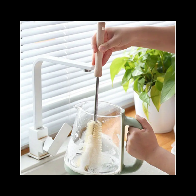 Escova de limpeza com cabo de madeira a limpar jarro de vidro na cozinha