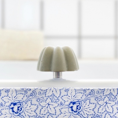Puxador verde ondulado em móvel branco com padrão azul de flores
