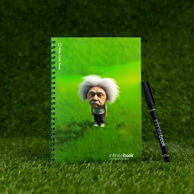 Caderno verde com figura de cabelo branco e marcador preto sobre relva