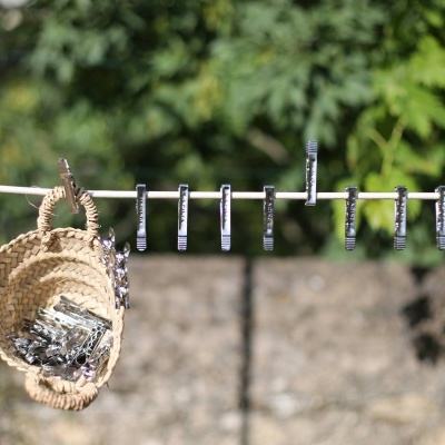 Varal com molas de metal prateado e cesta de palha pendurada com molas dentro