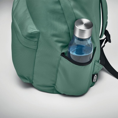 mochila verde com bolso lateral segurando garrafa transparente com tampa metálica