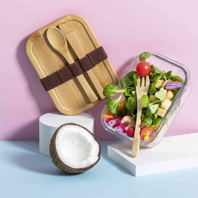 Conjunto de almoço com tupperware de vidro, talheres de bambu e coco aberto