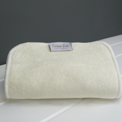 Toalha pequena creme com etiqueta Baba Boo sobre superfície branca riscada