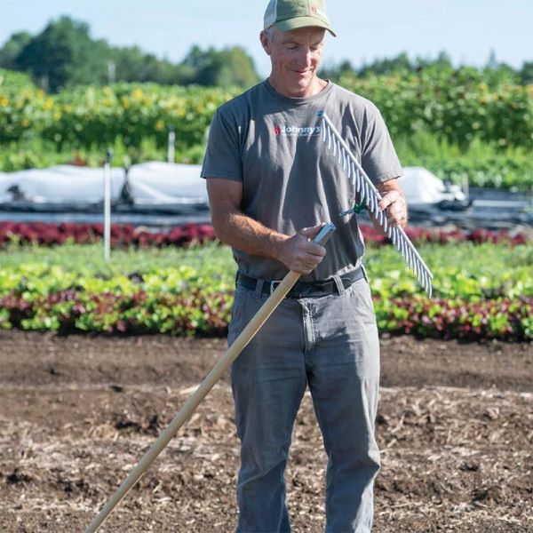 Cabeça de ancinho sistema Connecta Homem com roupa de trabalho segurando ancinho em campo agrícola
