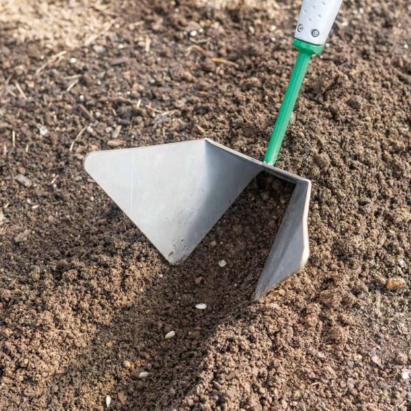 Ferramenta de nivelamento Row Pro sistema Connecta Enxada metálica com cabo verde a trabalhar na terra arada com sementes