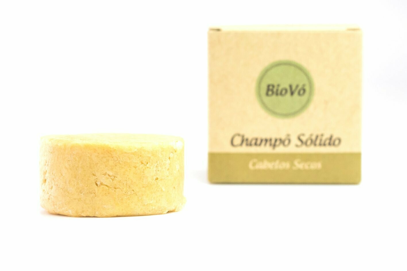 Champô Sólido Cabelos Secos Champô sólido amarelo com embalagem de papel branco e castanho claro com texto BioVó Champô Sólido