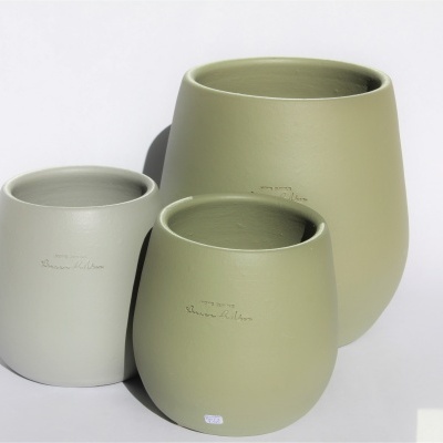 Três vasos de cerâmica verde claro de diferentes tamanhos num fundo branco.