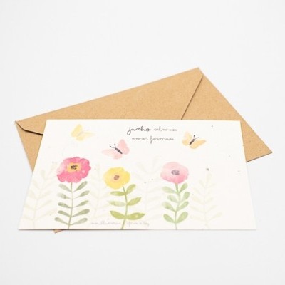Cartão decorativo com flores e borboletas ao lado de envelope castanho