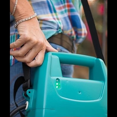 Mão segurando punho de dispositivo elétrico azul com indicador de luz verde