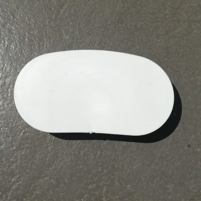 Peça branca oval em superfície cinzenta rugosa