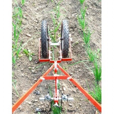 Equipamento agrícola vermelho com duas rodas pretas em solo