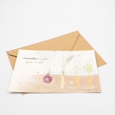Cartão ilustrado com vegetais e texto manuscrito junto a envelope castanho