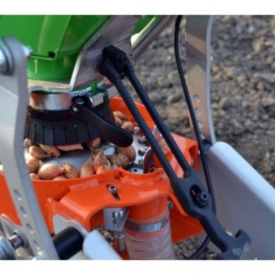 Máquina agrícola para plantar cebolas com partes metálicas laranja e verdes