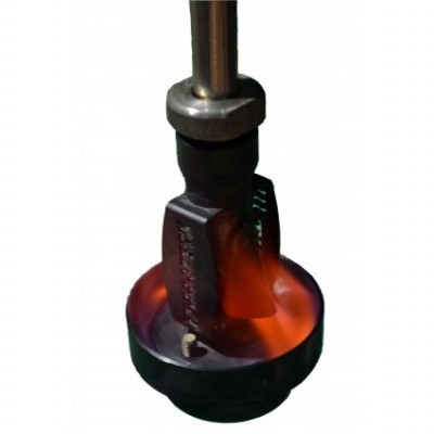 Extremidade metálica com luz laranja brilhante num equipamento industrial