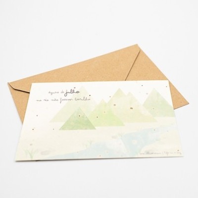 Cartão decorativo com ilustração de montanhas e texto manuscrito em português com envelope castanho.