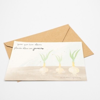 Postal com desenho de três cebolas e texto manuscrito acompanhado de envelope castanho