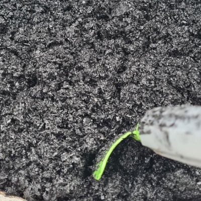 Superfície preta granulada com ferramenta branca e amarela a apontar para linha verde