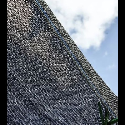 Tela preta de sombreamento em estrutura verde contra céu azul