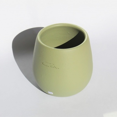 Vaso de cerâmica verde claro arredondado com inscrição e sombra
