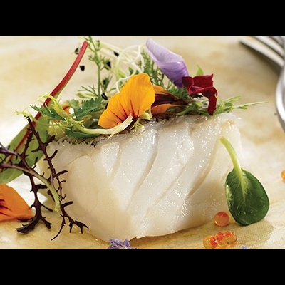 Prato com peixe branco e flores comestíveis decorativas