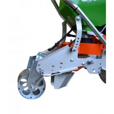 Parte inferior de máquina agrícola verde e laranja com estrutura metálica e roda perfurada