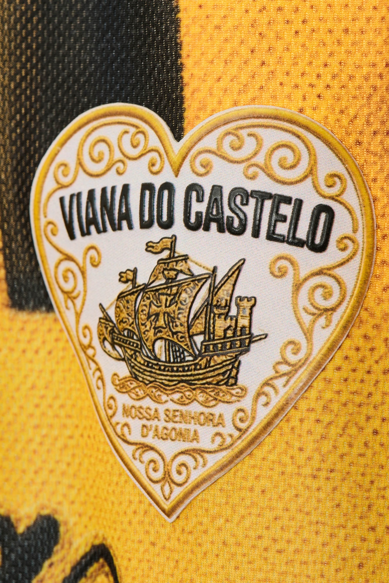Camisola de Jogo Retro - Edição Amarelo & Preto Etiqueta em forma de coração em tecido amarelo com padrão de malha.