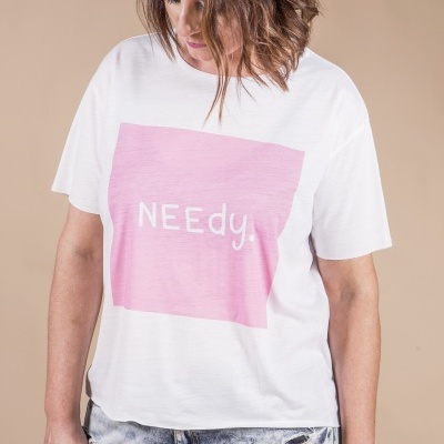 Pessoa a usar t-shirt branca com estampado rosa e texto 