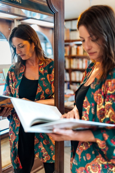 Mulher com casaco floral verde a ler livro